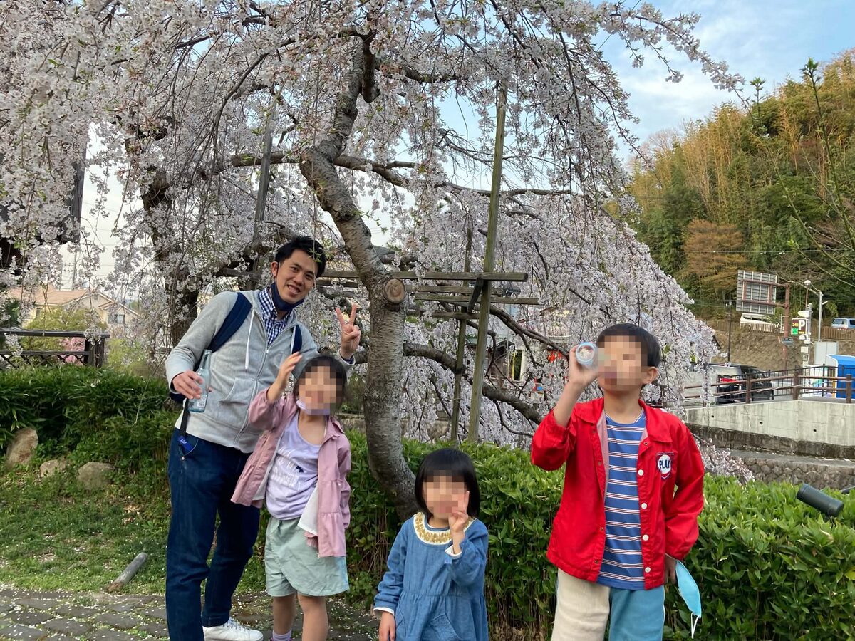 満開の桜の下で子どもたちと過ごす講師
